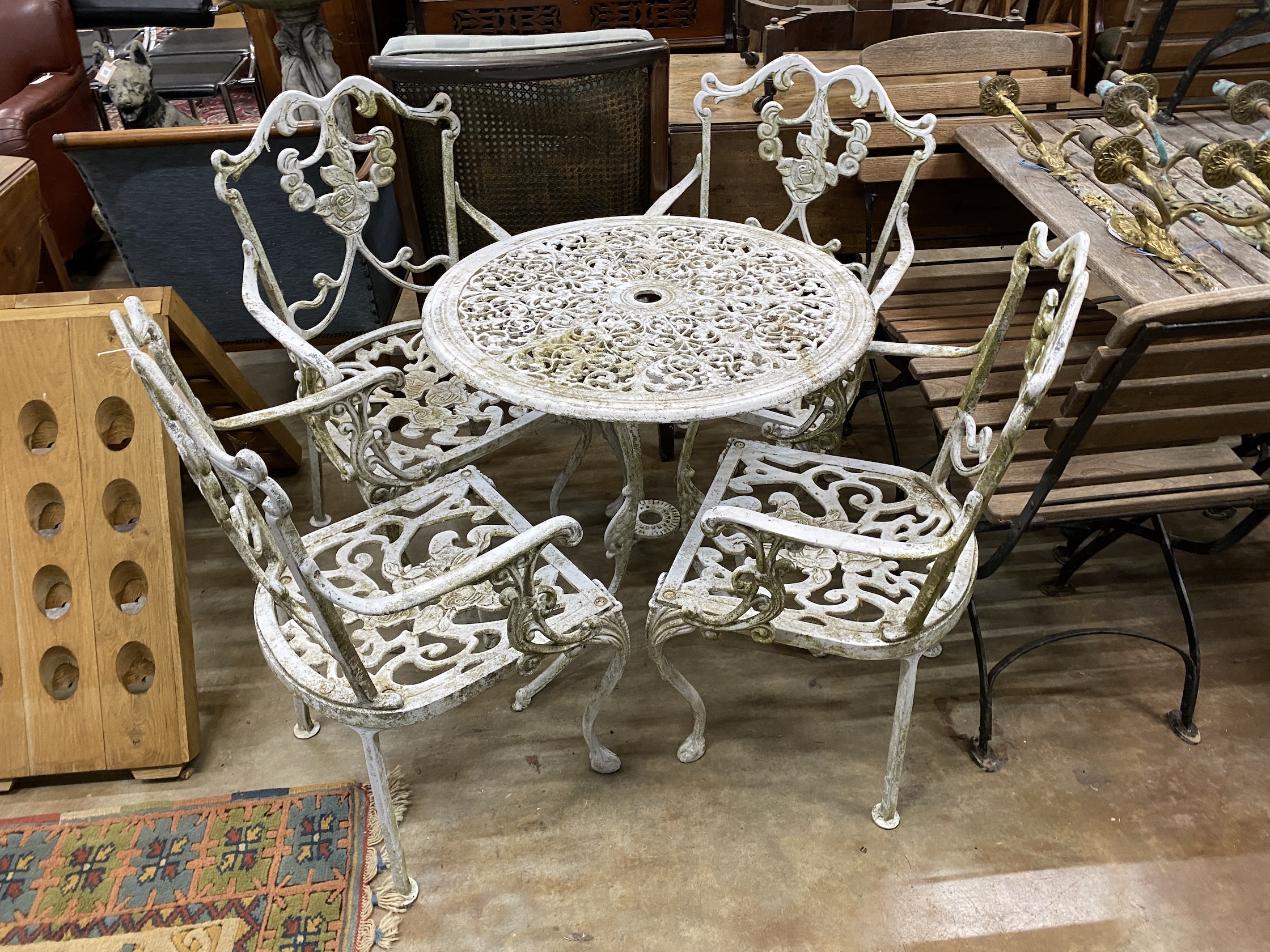 A painted aluminium circular garden table, diameter 68cm, height 68cm, together with four aluminium garden elbow chairs